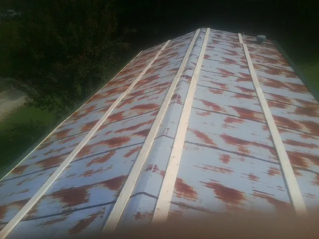Rusted metal roof panels with new wood purlins before replacement — Storm Damage Roof Repair in Machesney Park by Roofing Brothers