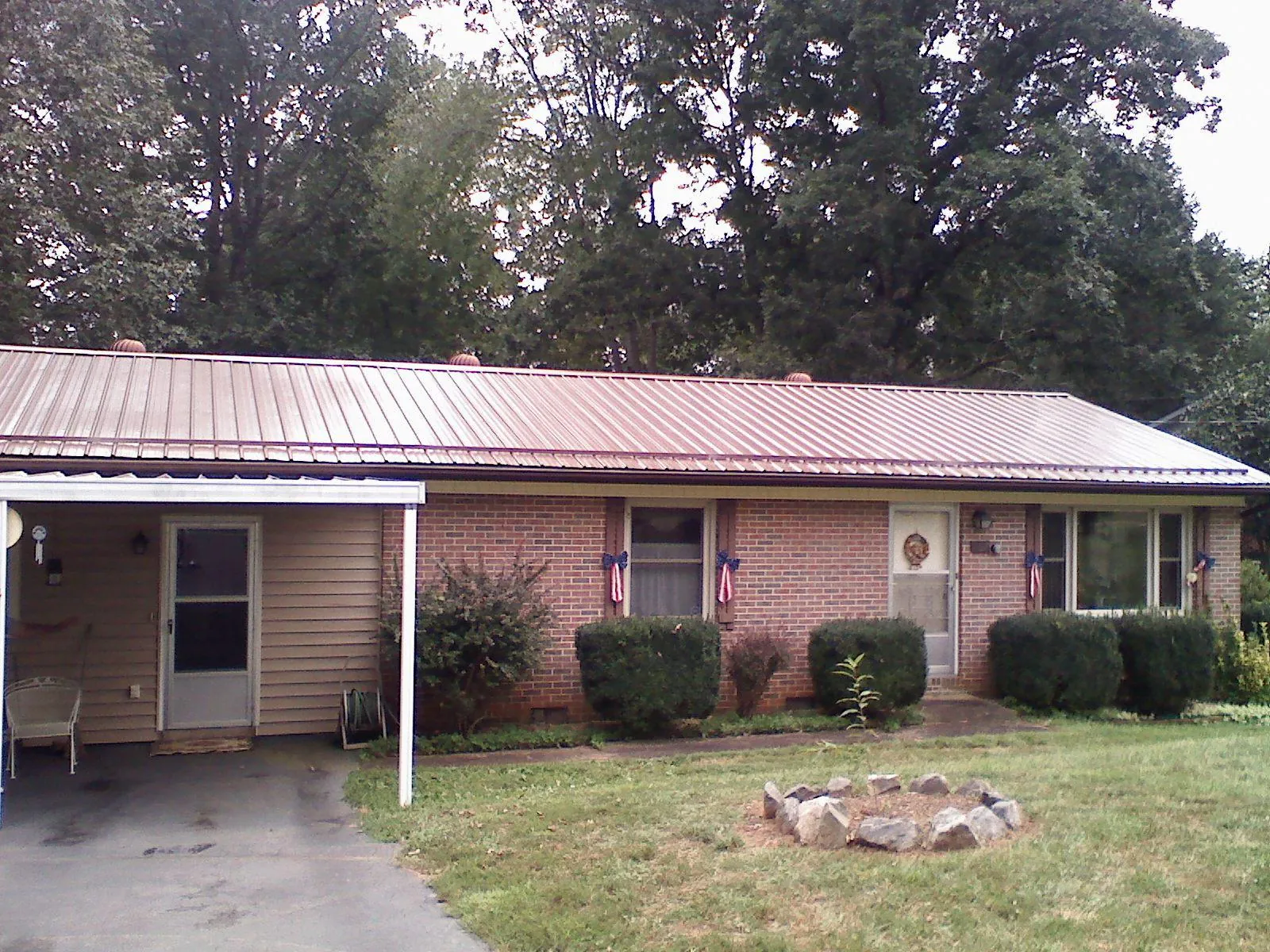 Bronze metal roof and carport on a brick ranch home — Roof Repair work by our crew in Machesney Park