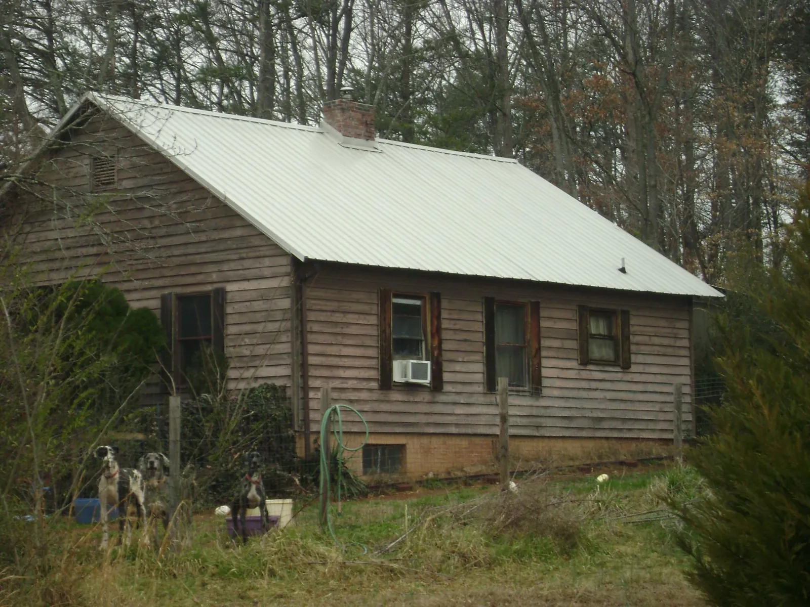 White metal roof on an old wood sided farmhouse, from a Metal Roof Installation job in Machesney Park