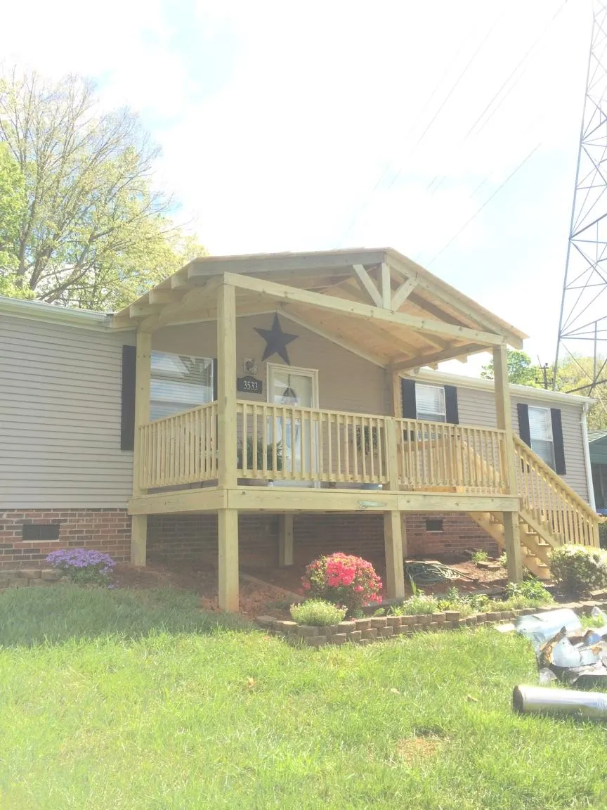New gabled porch roof and deck railing added to a ranch home in Machesney Park